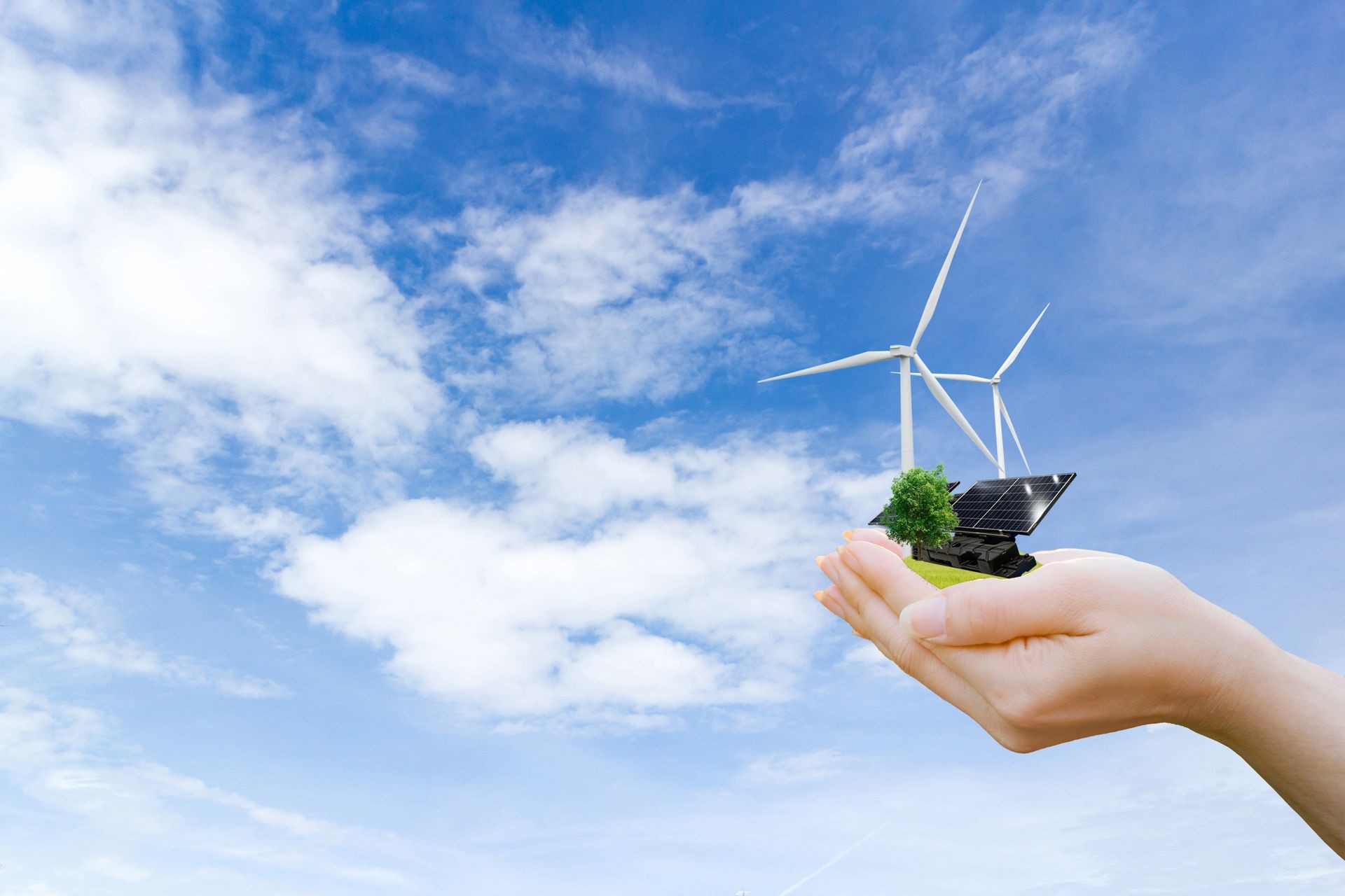 Ecology concept hands holding tree electrical energy clean wind turbine and solar cell the future